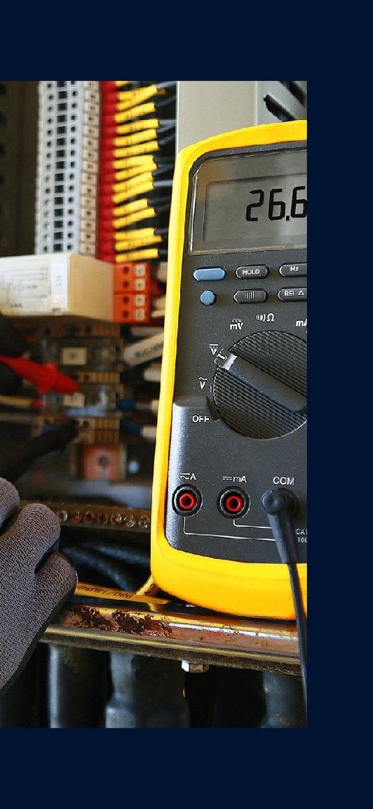 BMS specialist testing a control panel with a multimeter